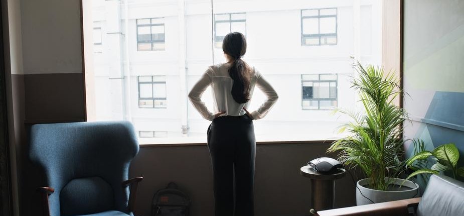 female-executive-looks-out-modern-office-window